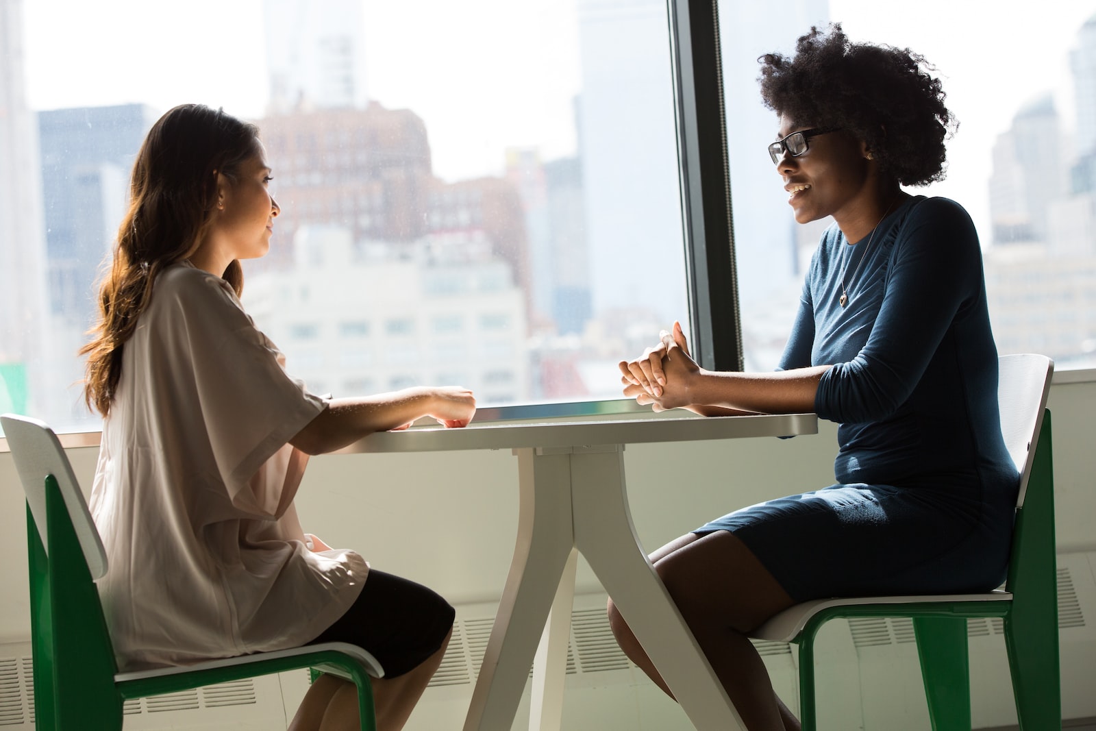 Photo by Christina @ wocintechchat.com two women sitting beside table and talking